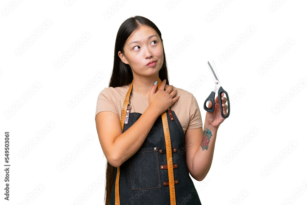 Young Asian seamstress woman over isolated background looking up while smiling Young Asian seamstress woman over isolated background looking up while smiling