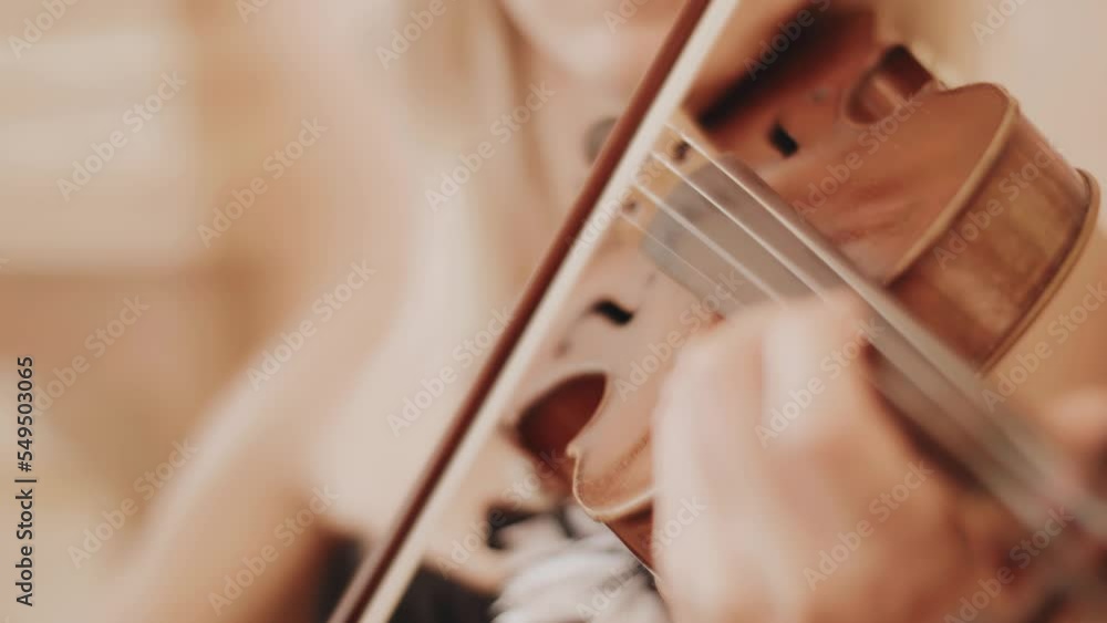 The violinist plays the violin calmly and gently. The camera takes a close-up of her hands and strings The violinist plays the violin calmly and gently. The camera takes a close-up of her hands and strings