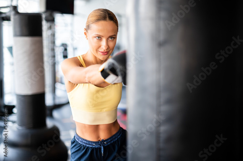 Beautiful young woman lifting dumbbells in a gym