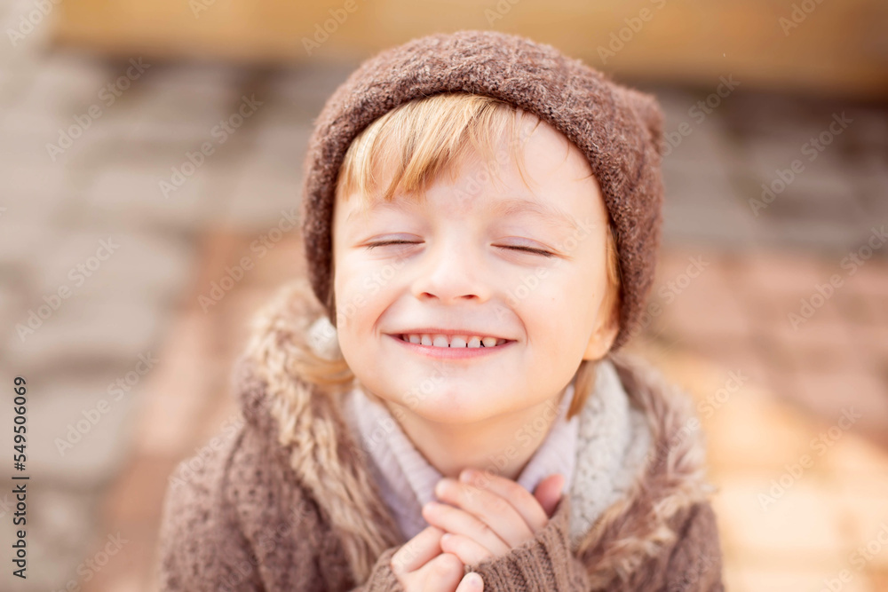 a large portrait of a small happy boy with a toothy smile with big eyes in a knitted hat a large portrait of a small happy boy with a toothy smile with big eyes in a knitted hat