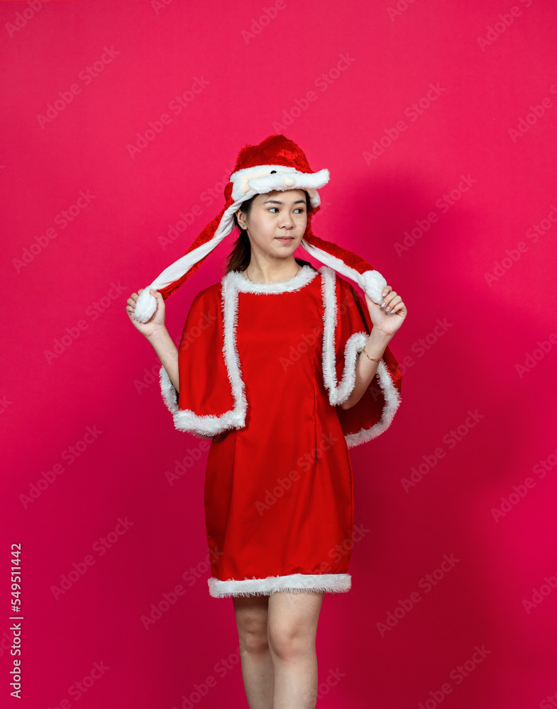 Posing Asian Young Woman at With Christmas Attire on a Red Background