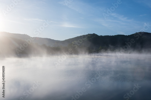 Foggy lake at dawn sunrise
