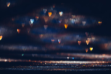 Glowing in the dark colorful heart shaped bokeh lights. Valentine's Day texture background