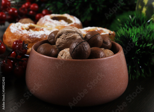 Macadamia nut and walnuts in a clay bowl on the Christmas table, for the New Year. Close-up