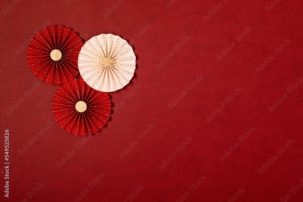 Chinese new year festival or wedding decoration over red background. Traditional lunar new year paper fans. Flat lay, top view, banner