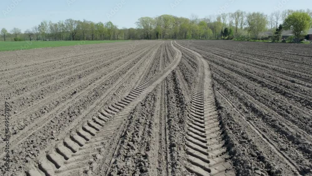Perfect lines of brown plowed field vertical top view. Smooth stripes on a dirt field Drone view. Arable land flying at low altitude. Plowed field in Belgium aerial view. High quality 4k footage Perfect lines of brown plowed field vertical top view. Smooth stripes on a dirt field Drone view. Arable land flying at low altitude. Plowed field in Belgium aerial view. High quality 4k footage
