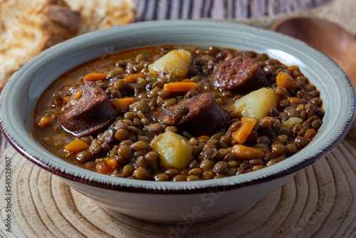 Close-up of a traditional lentil soup with legs, carrots and chorizo. Mediterranean cuisine