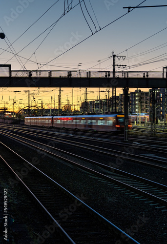 illuminated moving train and train tracks at sunset