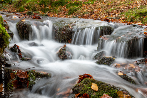 Long exposure of a waterfall flowing into the Weir Water river at Robbers Bridge in Exmoor National Park