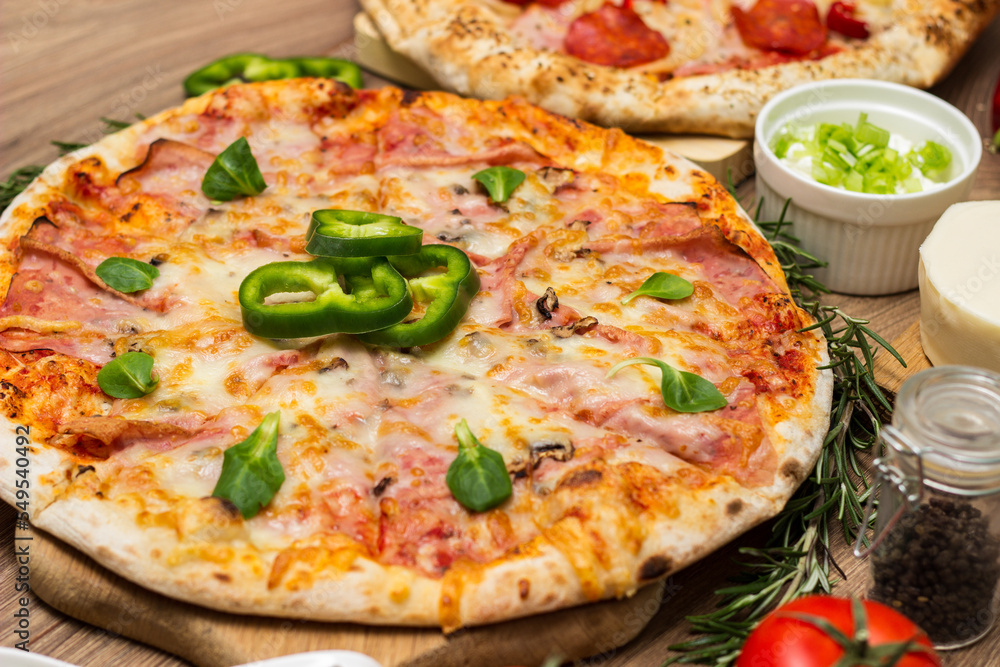 Pepperoni pizza and pizza Capricciosa with mozzarella cheese, ham, tomato sauce, salami, mushroom, pepper, spices and fresh basil