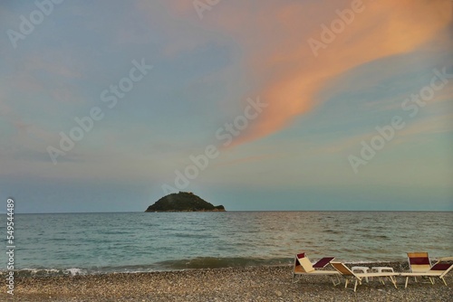 Scenic shot of turtle-shaped Gallinara island from the beach during the sunset in Liguria, Italy