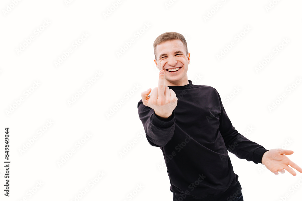 a laughing man in black shows his middle finger on a white background. a laughing man in black shows his middle finger on a white background.