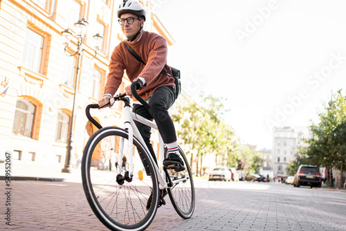 A man on a bicycle in a helmet goes to work urban eco transport © muse studio