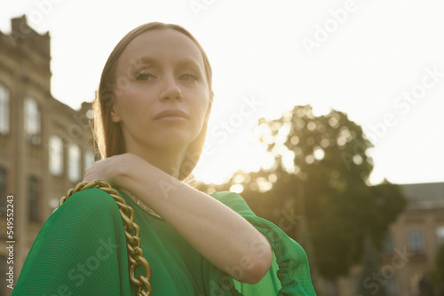 Young beautiful stylish woman walking city streets on sunset photo