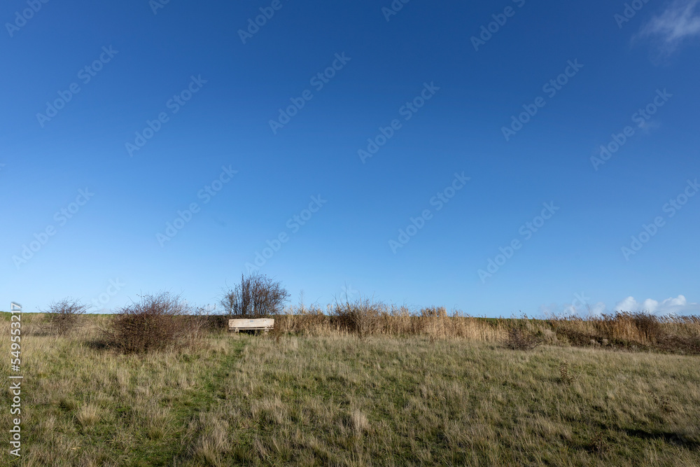 Island of Texel. Netherlands. Ceres nature park. Bench and clouds. Waddenzee Unesco. Coast North Sea. Island of Texel. Netherlands. Ceres nature park. Bench and clouds. Waddenzee Unesco. Coast North Sea.