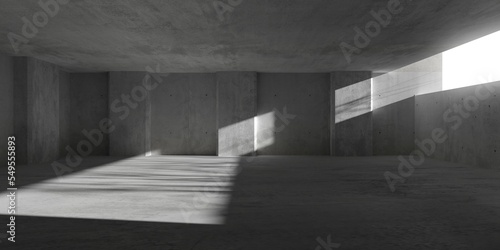 Abstract large, empty, modern concrete room with sunlight from wall opening, pillars along the walls and rough floor - industrial interior background template