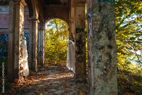 A funny image of two people in ghost costumes and sunglasses in an abandoned building