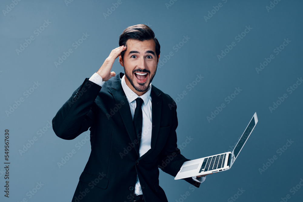 Man business looking at laptop and working online smiling with teeth surprised hand up via internet in business suit video call business talks win on blue background copy place Man business looking at laptop and working online smiling with teeth surprised hand up via internet in business suit video call business talks win on blue background copy place