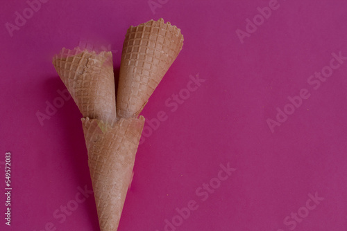 Three cones stacked. Empty ice cream cone isolated on pink background