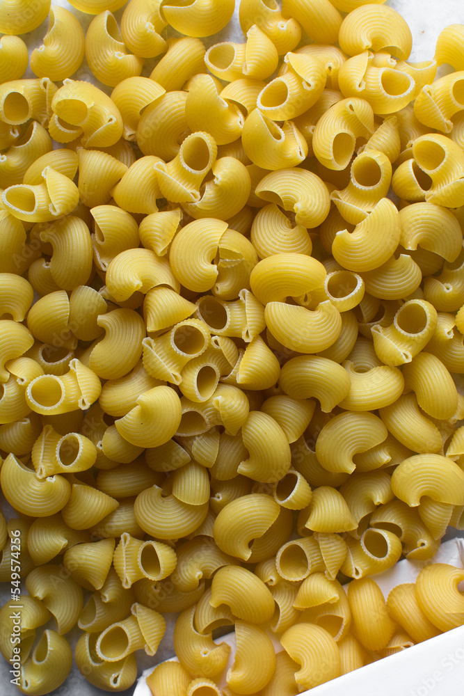 Flat lat of uncooked pipe rigate pasta, top view of pipe rigate pasta shells, dry uncooked macaroni Flat lat of uncooked pipe rigate pasta, top view of pipe rigate pasta shells, dry uncooked macaroni