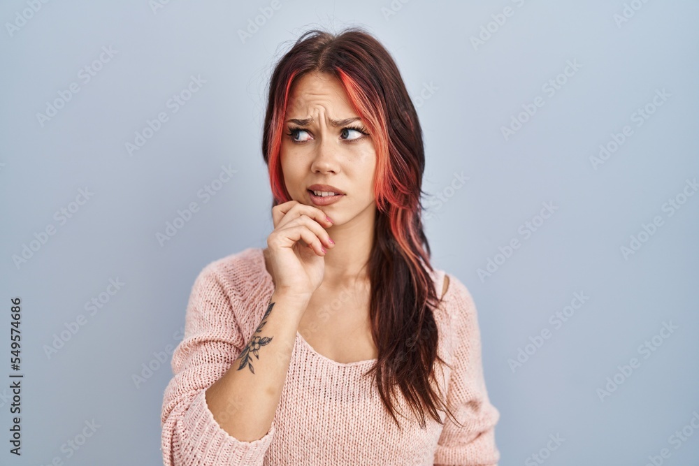 Young caucasian woman wearing pink sweater over isolated background thinking worried about a question, concerned and nervous with hand on chin Young caucasian woman wearing pink sweater over isolated background thinking worried about a question, concerned and nervous with hand on chin