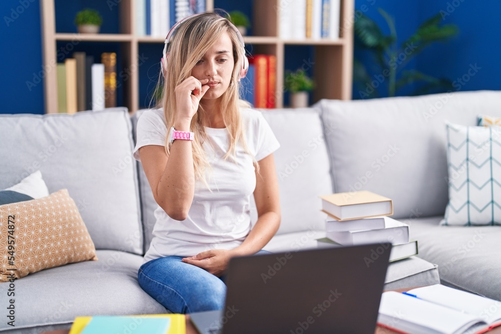 Young blonde woman studying using computer laptop at home mouth and lips shut as zip with fingers. secret and silent, taboo talking Young blonde woman studying using computer laptop at home mouth and lips shut as zip with fingers. secret and silent, taboo talking