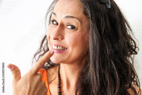 Middle-aged woman, with tooth implant and receding gums, on a white background