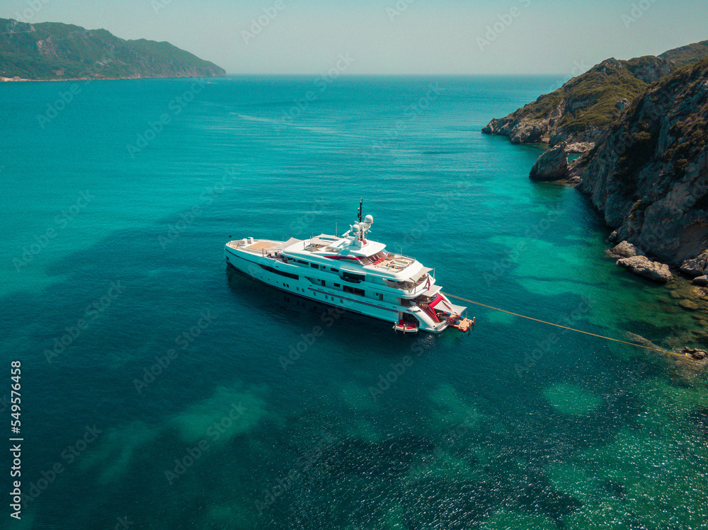 Aerial drone view of  luxury private yacht anchored on porto timoni beach in corfu