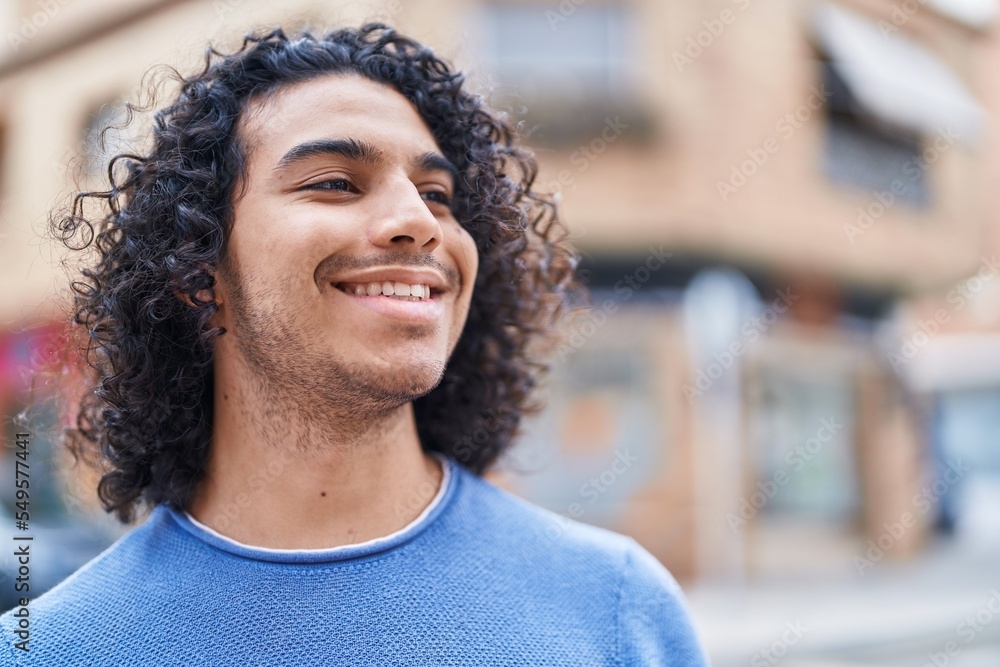 Young latin man smiling confident looking to the side at street Young latin man smiling confident looking to the side at street