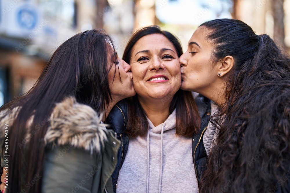 Three woman mother and daughters standing together and kissing at street Three woman mother and daughters standing together and kissing at street