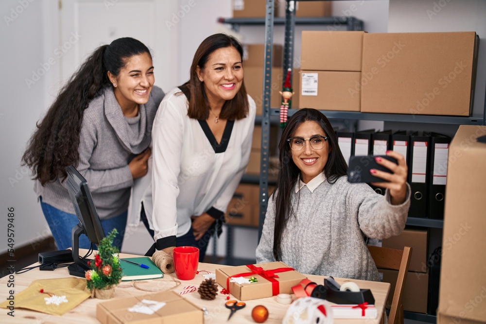 Fototapeta premium Three woman ecommerce business workers making selfie by smartphone at office