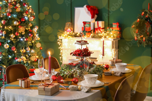 Romantic table setting for Christmas dinner at home in evening