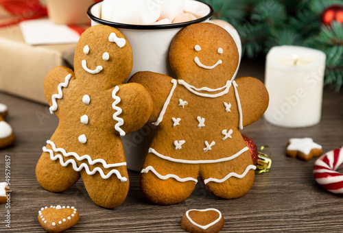 Gingerbread man and gingerbread woman on the background of Christmas decorations. Close up.