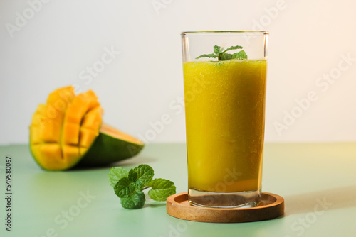 Fresh Mango Juice. Served with a natural green background color along with sliced ​​Arumanis mango. photo