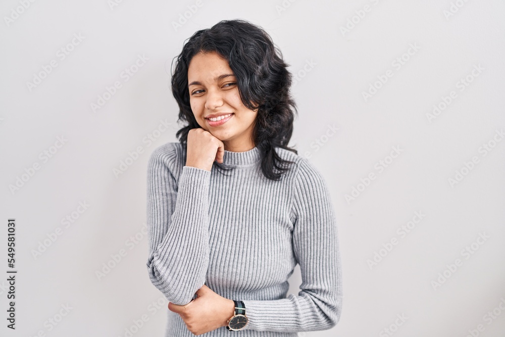 Hispanic woman with dark hair standing over isolated background with hand on chin thinking about question, pensive expression. smiling and thoughtful face. doubt concept. Hispanic woman with dark hair standing over isolated background with hand on chin thinking about question, pensive expression. smiling and thoughtful face. doubt concept.