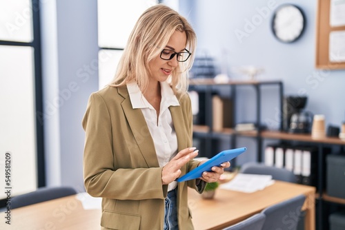 Young blonde woman business worker using touchpad at office