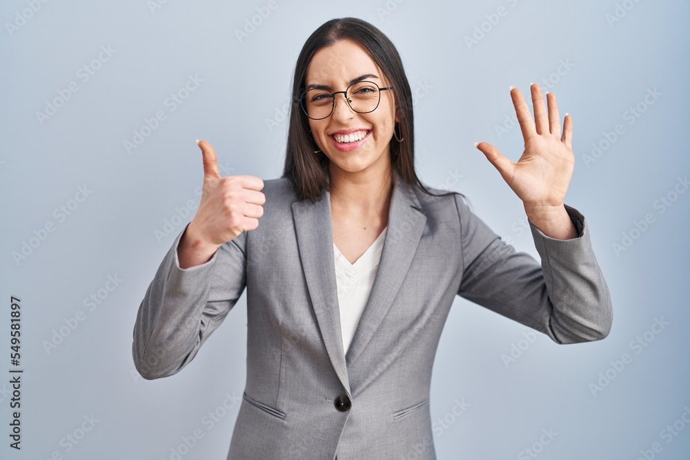Hispanic business woman wearing glasses showing and pointing up with fingers number six while smiling confident and happy. Hispanic business woman wearing glasses showing and pointing up with fingers number six while smiling confident and happy.