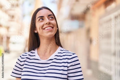 Young hispanic woman smiling confident standing at street