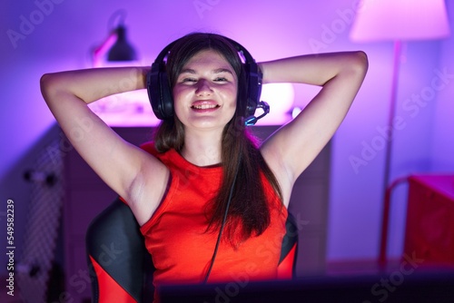 Young caucasian woman streamer smiling confident relaxed with hands on head at gaming room