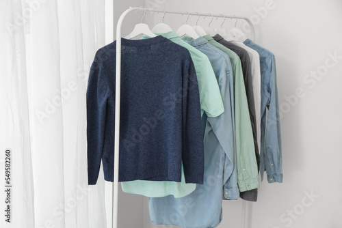Fotografie Rack with male clothes near light wall