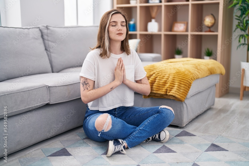 Young woman doing yoga exercise sitting on floor at home Young woman doing yoga exercise sitting on floor at home