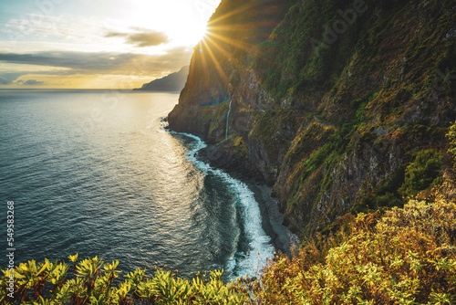 Waterfall flowing into the sea in a picturesque morning atmosphere. Viewpoint Véu da Noiva, Madeira Island, Portugal, Europe. photo