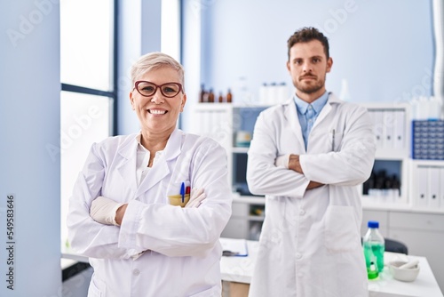Mother and son scientist partners standing with arms crossed gesture at laboratory
