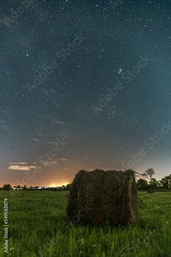 haystack in a field under a starry sky