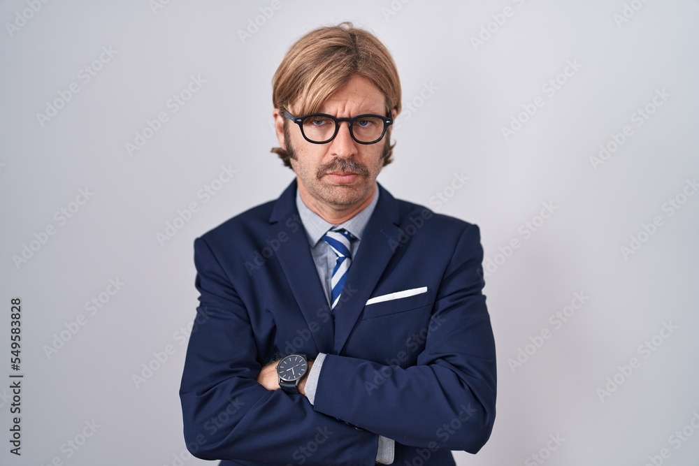 Caucasian man with mustache wearing business clothes skeptic and nervous, disapproving expression on face with crossed arms. negative person.