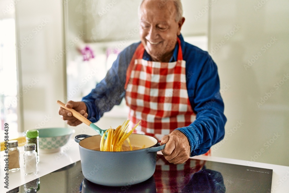 Senior man smiling confident cooking spaghetti at kitchen Senior man smiling confident cooking spaghetti at kitchen