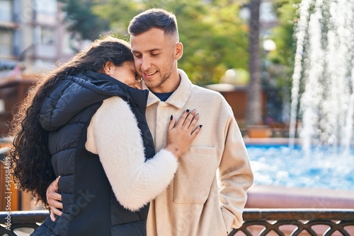 Man and woman couple hugging each other standing at park
