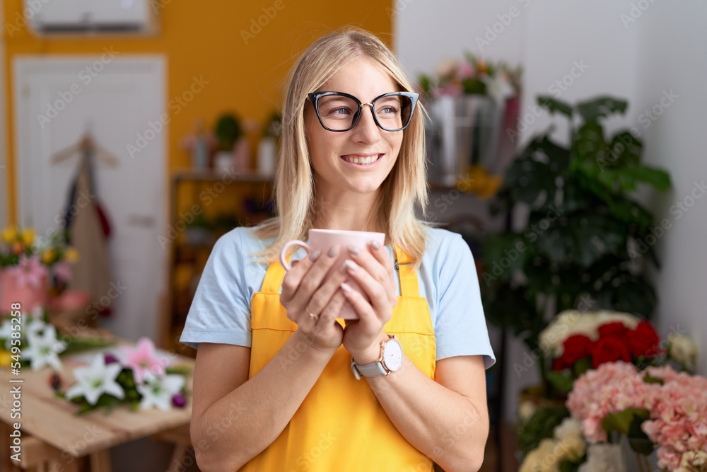 Young blonde woman florist smiling confident drinking cup of coffee at flower shop Young blonde woman florist smiling confident drinking cup of coffee at flower shop