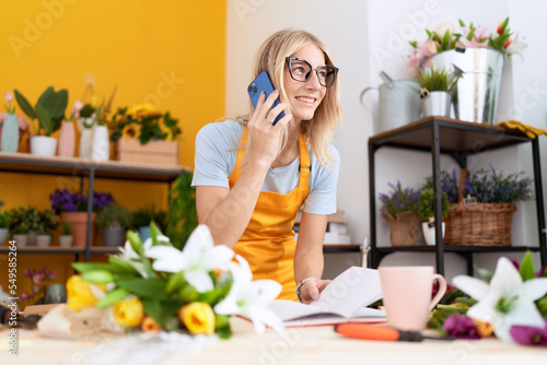 Wallpaper Mural Young blonde woman florist talking on smartphone reading book at flower shop Torontodigital.ca