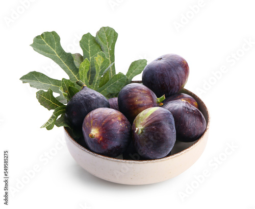 Bowl of fresh ripe figs and leaves on white background